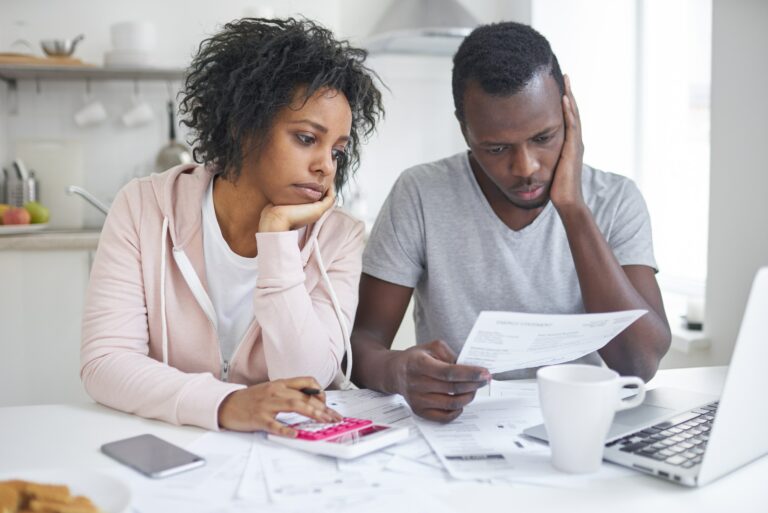 Couple Looking At Bills To Pay Stressed