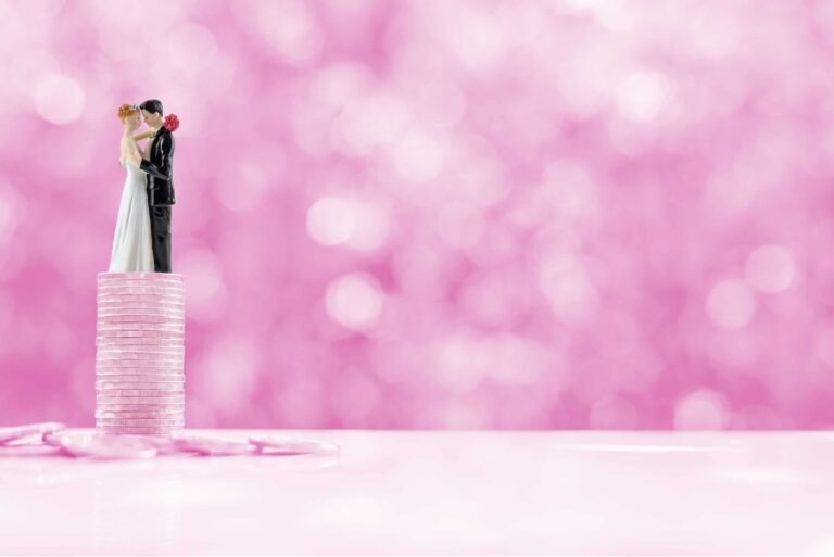 Bride Groom Figurine On Stack Of Pink Coins Glitter Wedding Day Expenses
