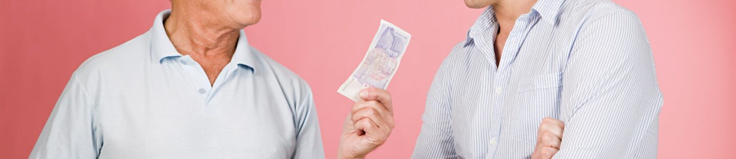 Elderly Man Lending Cash Younger Man