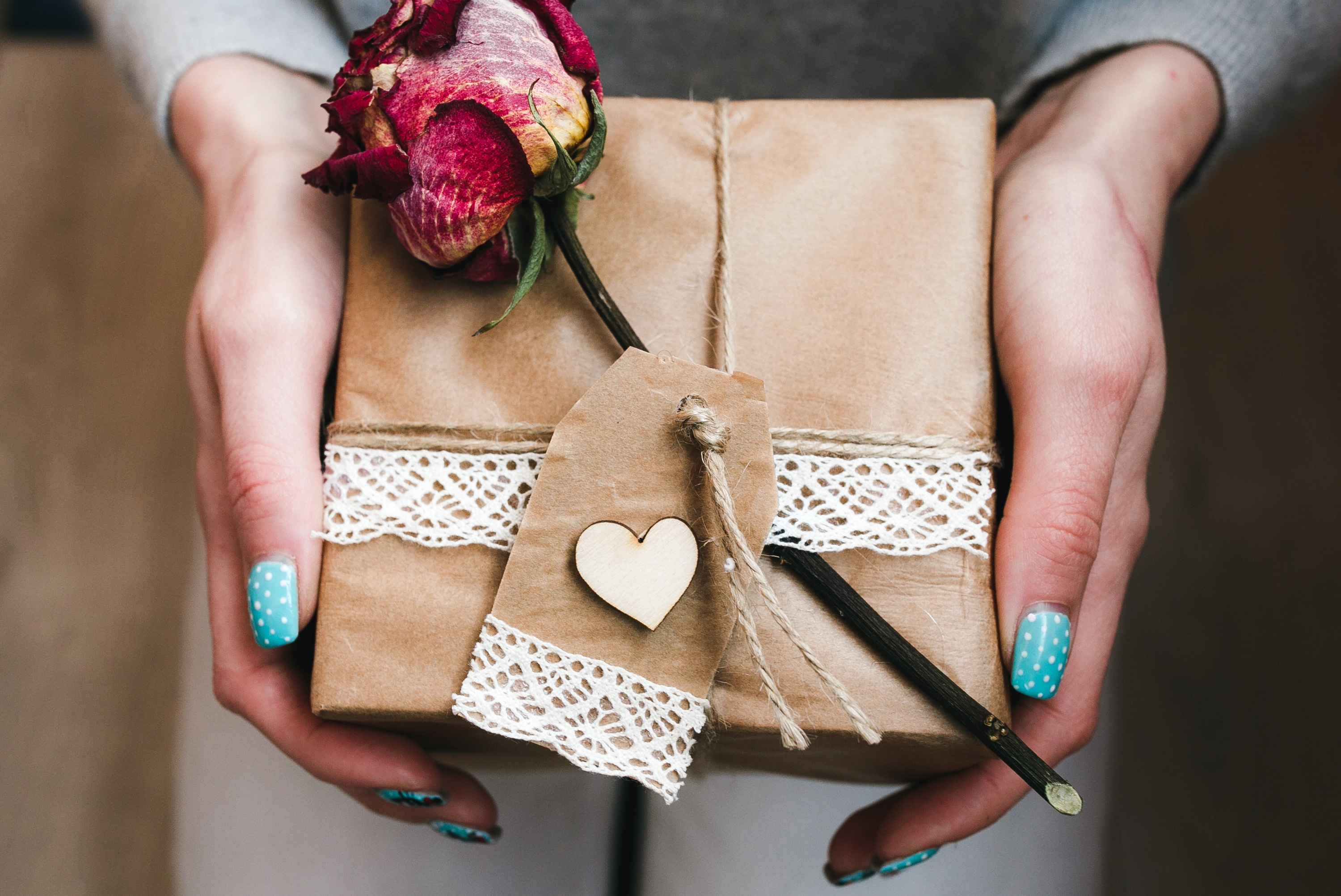 https://www.moneycrashers.com/wp-content/uploads/2015/02/woman-holding-wrapped-gift-with-rose-brown-wrapper.jpg