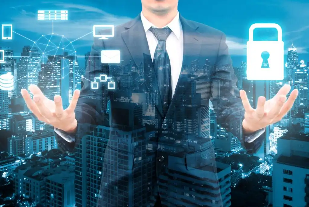 A man in a suit stands with open hands over a cityscape, surrounded by digital icons such as a lock, email, and network symbols, representing cybersecurity and data protection.