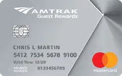 A silver Amtrak Guest Rewards Mastercard credit card with a chip, card number, expiration date, cardholder name, and Mastercard logo displayed on the front.