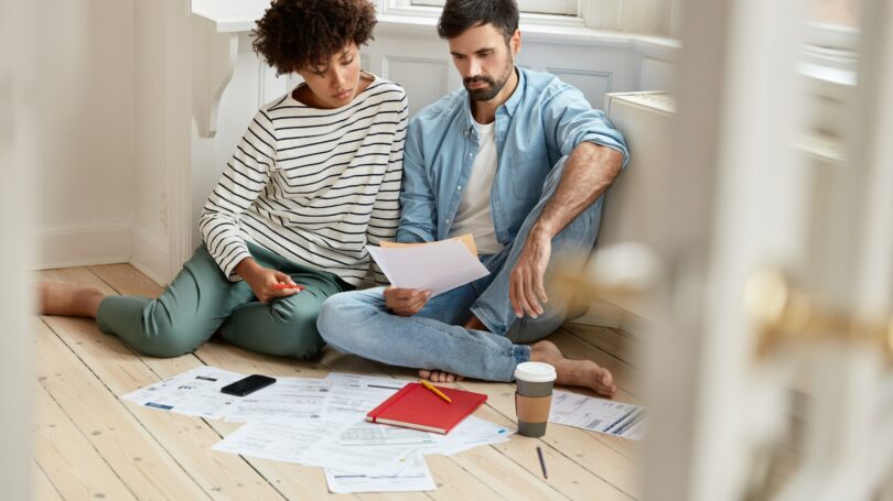 Couple Discussing Paperwork Bills Finances Mortgage House