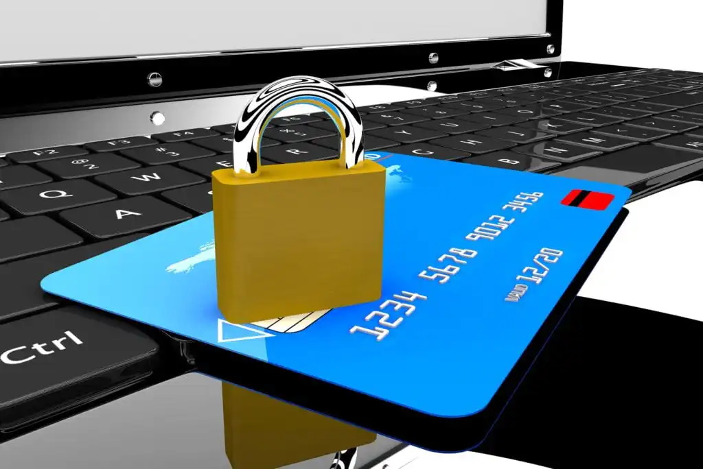 A gold padlock sits on a blue credit card placed on a laptop keyboard, symbolizing online payment security and protection of financial information.