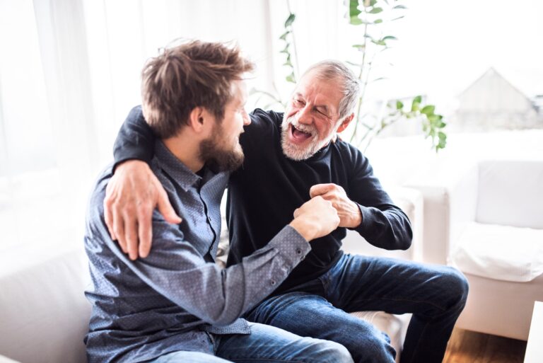 Father Son In Living Room Embraving Sofa