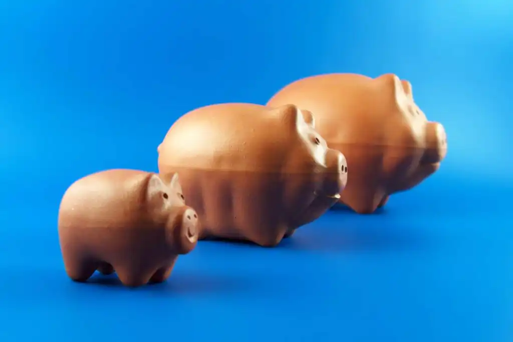 Three piggy banks of varying sizes=
