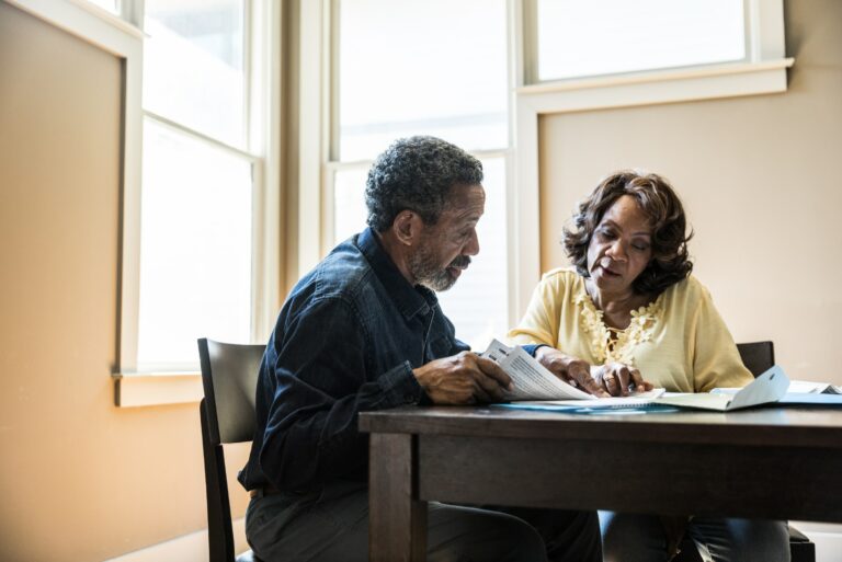 Man Woman Reading Papers Kitchen Table