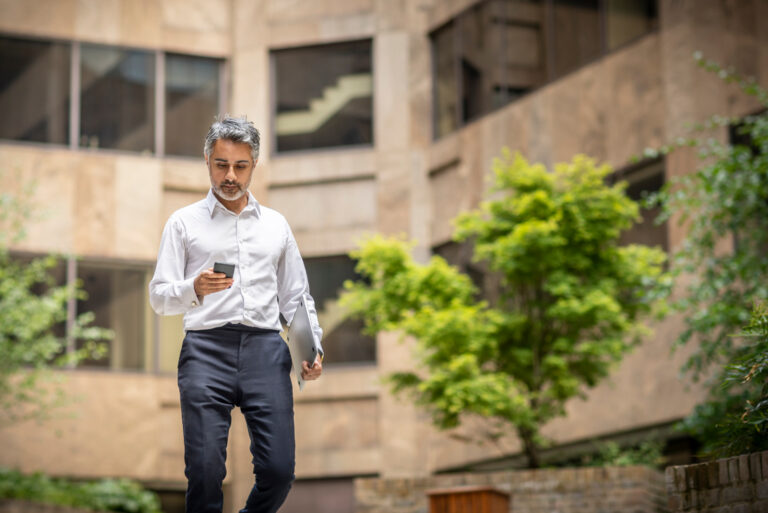 Businessman Walking Holding Smartphone
