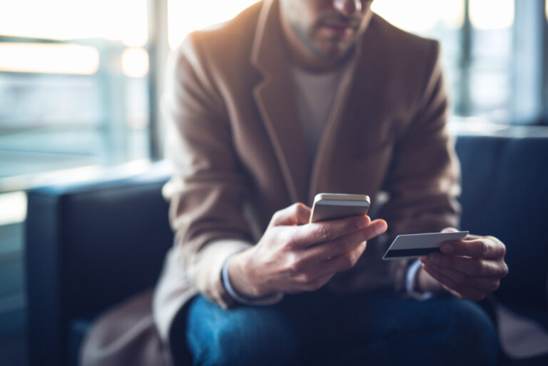 Man Sitting Holding Phone Credit Card