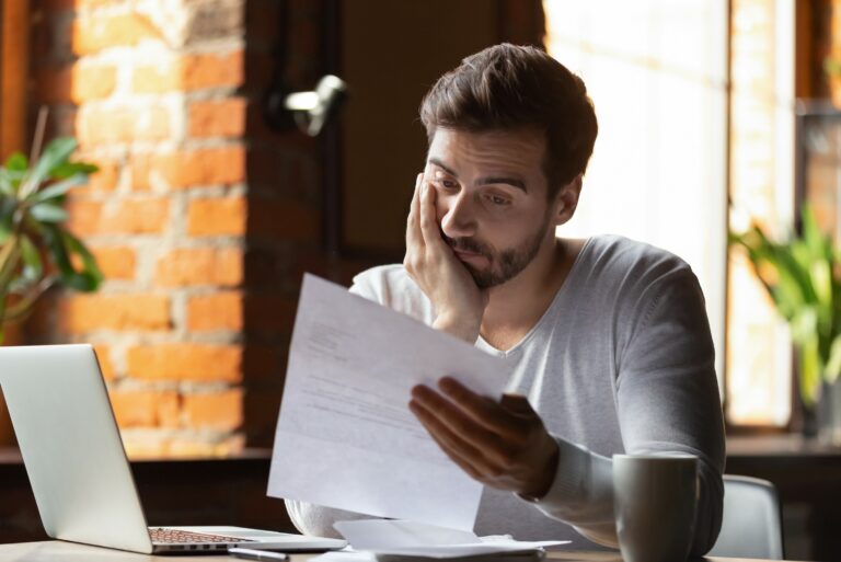 Man Looking At Student Loan Papers