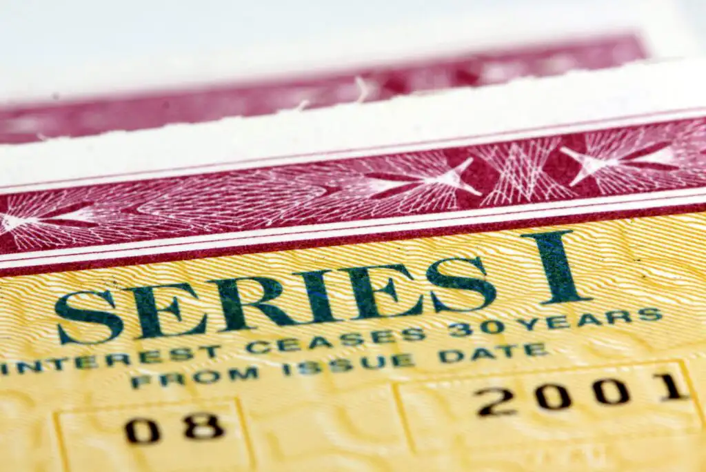 Close-up of a U.S. Treasury Series I savings bond, showing part of the word SERIES I in green text and detailed red and yellow security patterns.
