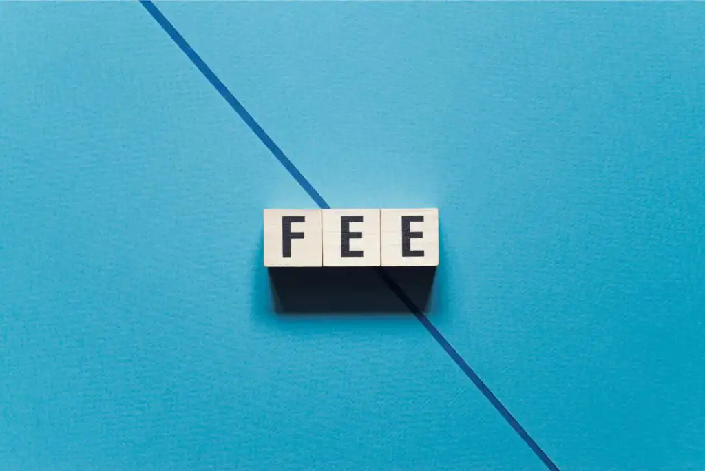 Three wooden blocks with black letters spelling FEE are arranged in a row on a blue background with a diagonal line running across it.