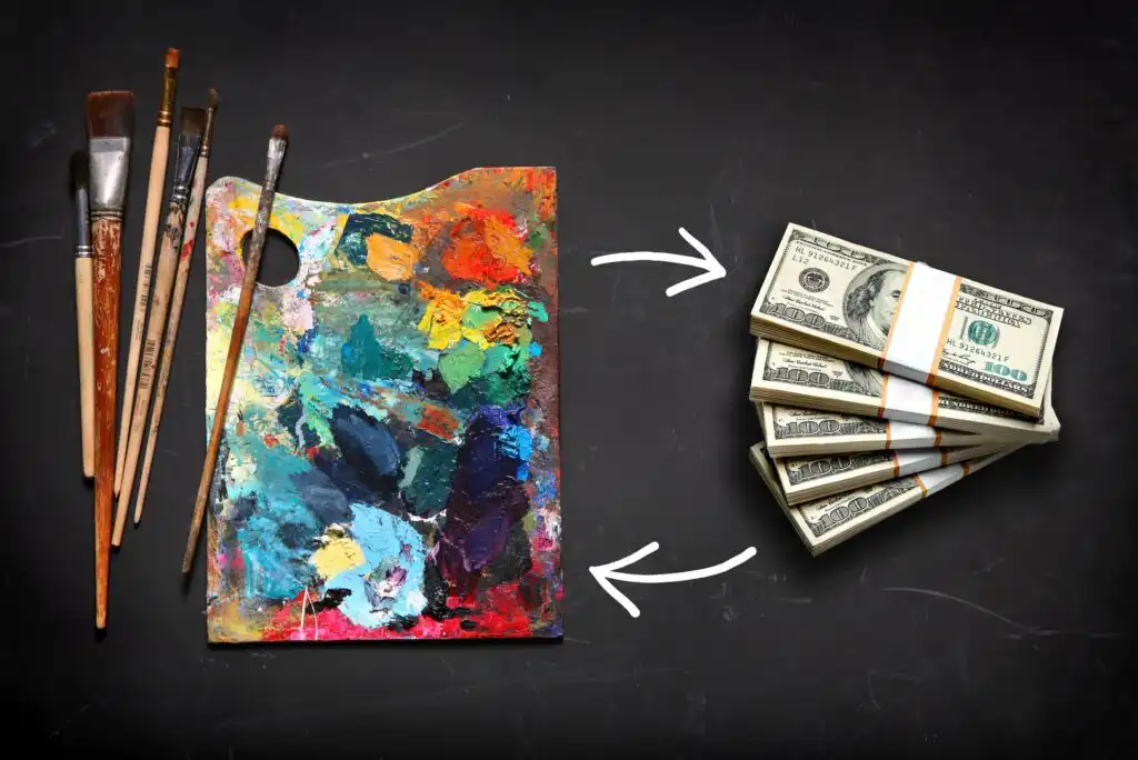 A set of paintbrushes and a colorful artist’s palette on the left, with two white arrows pointing toward stacks of U.S. hundred-dollar bills on the right, suggesting art turning into money.