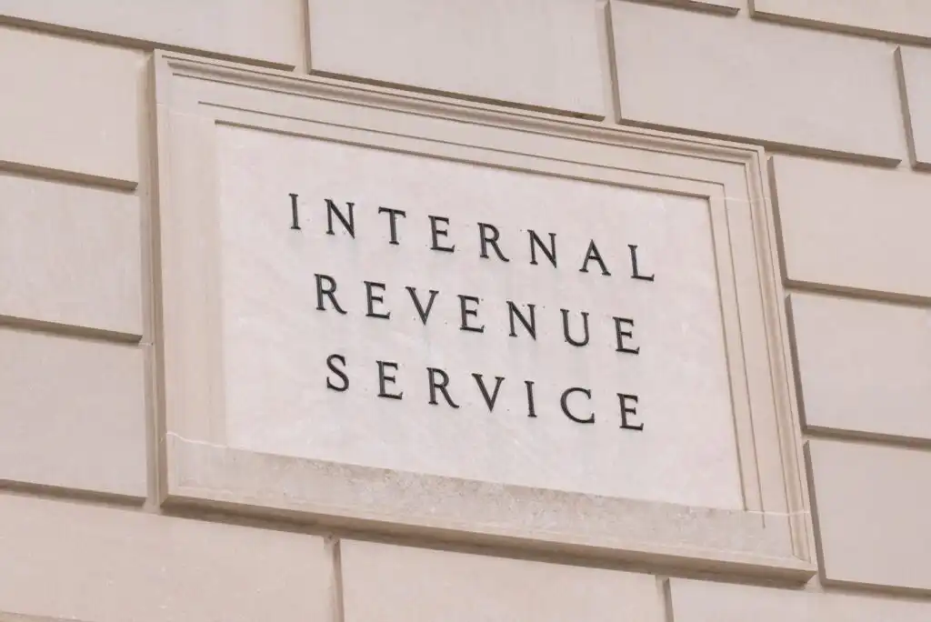 A stone sign on a beige brick wall reads Internal Revenue Service in black capital letters.