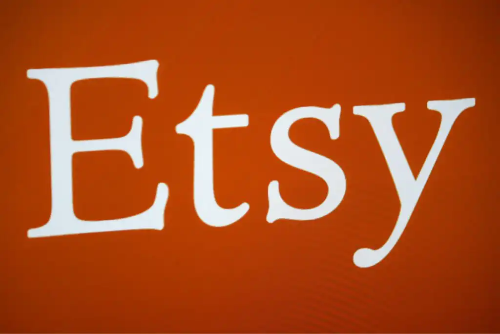 The white Etsy logo is displayed in large serif font against an orange background.