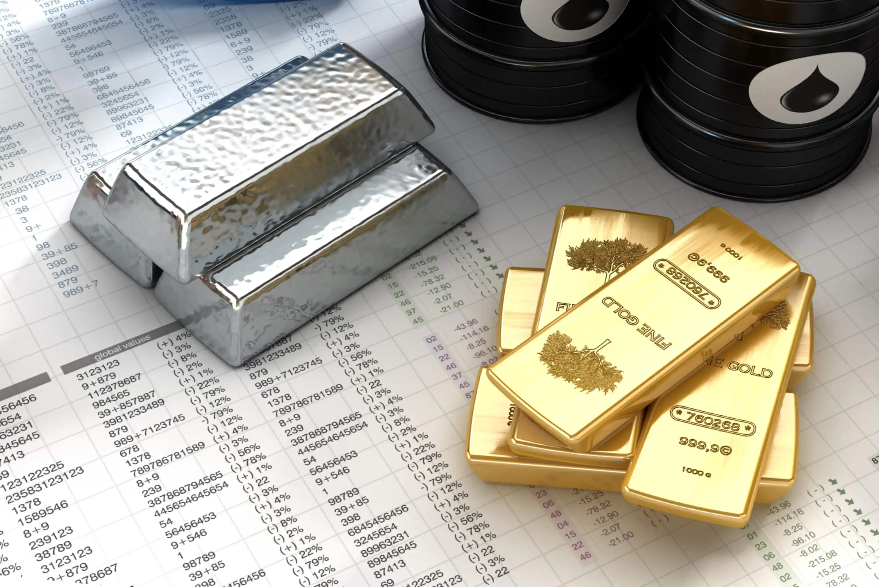 Two silver bars, several gold bars, and black oil barrels are placed on top of financial spreadsheets with numbers and data, symbolizing commodities and investment assets.
