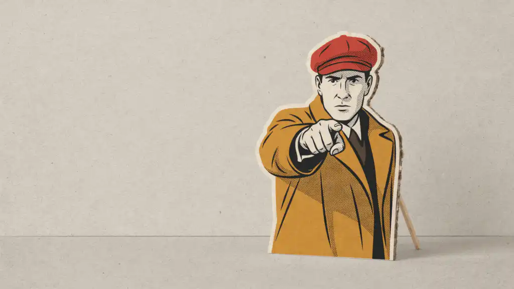 A cardboard cutout of a stern man pointing straight at the viewer, propped up from behind by one thin wooden stick.