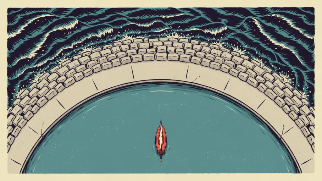 Aerial view of a curved stone breakwater sheltering a small red sailboat on calm teal water from dark waves outside.