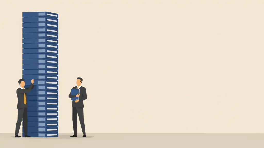 A lawyer touches a towering stack of navy case binders while a second lawyer holds a single binder