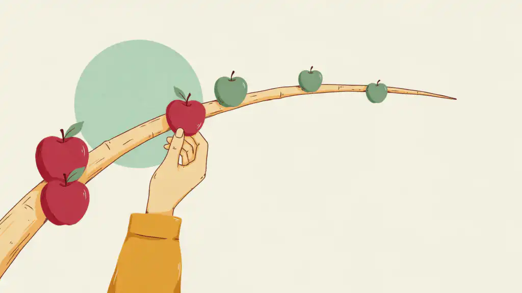 A hand picks a ripe red apple from a branch where three green apples are left to ripen