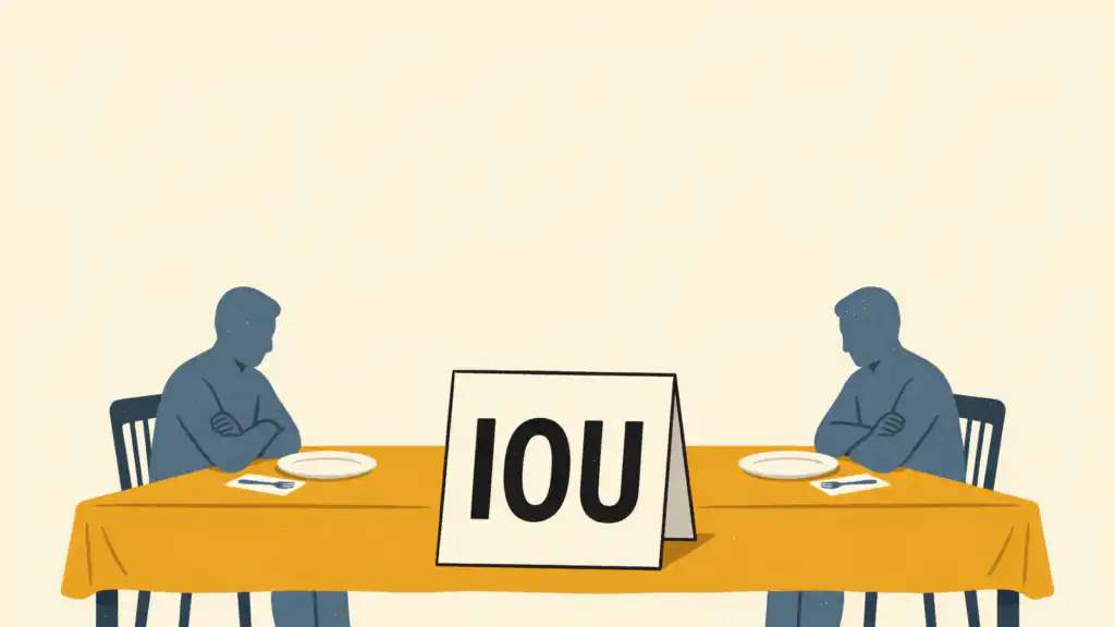 Two men with folded arms sit at opposite ends of a dinner table with a large IOU card standing between them