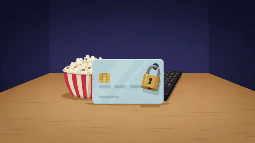 A pale blue credit card with a brass padlock through its corner stands on a wood table, popcorn and a TV remote behind it.